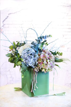 Bouquet con hortensias variadas en una bolsa fácil de llevar.
